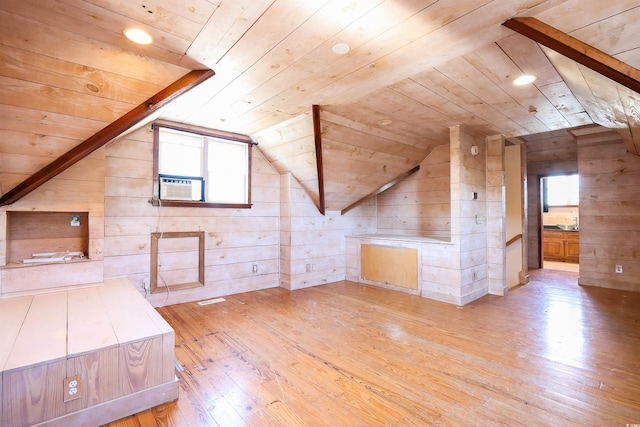 bonus room with light hardwood / wood-style flooring, wooden ceiling, and wood walls