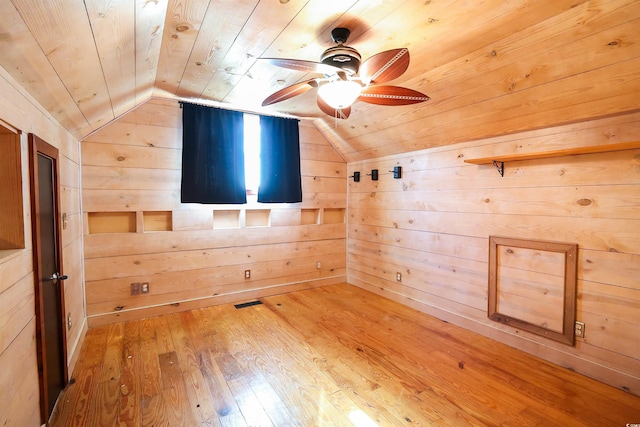 additional living space featuring lofted ceiling, hardwood / wood-style flooring, wooden ceiling, and wood walls