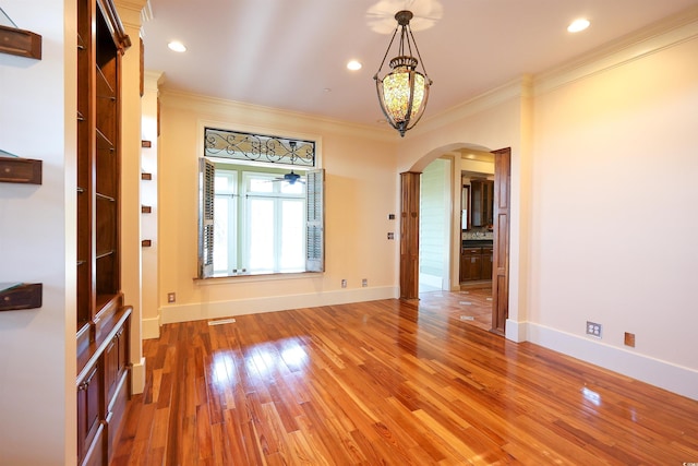 unfurnished room with ornamental molding and hardwood / wood-style floors