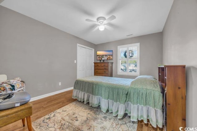 bedroom featuring ceiling fan, a closet, and wood-type flooring