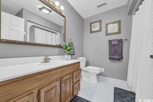 bathroom with tile patterned flooring, vanity, and toilet