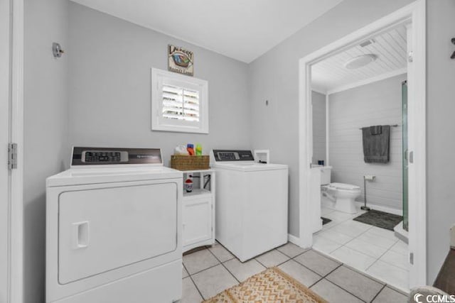 laundry room with cabinets, light tile patterned floors, and separate washer and dryer