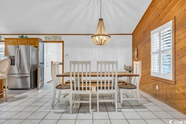 unfurnished dining area featuring a notable chandelier, light tile patterned floors, and wooden walls