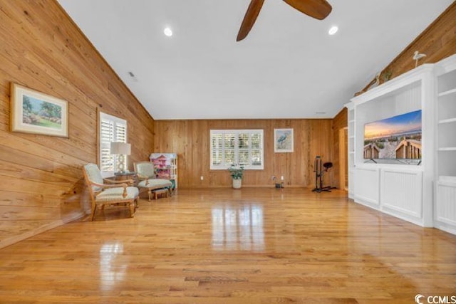 unfurnished room with wooden walls, ceiling fan, and lofted ceiling