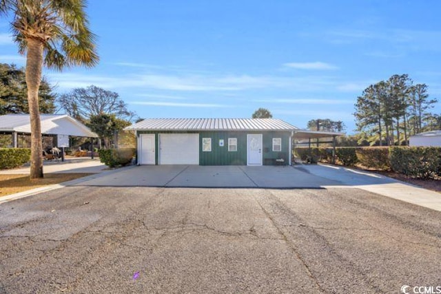 view of front of home featuring a carport, a garage, and an outdoor structure