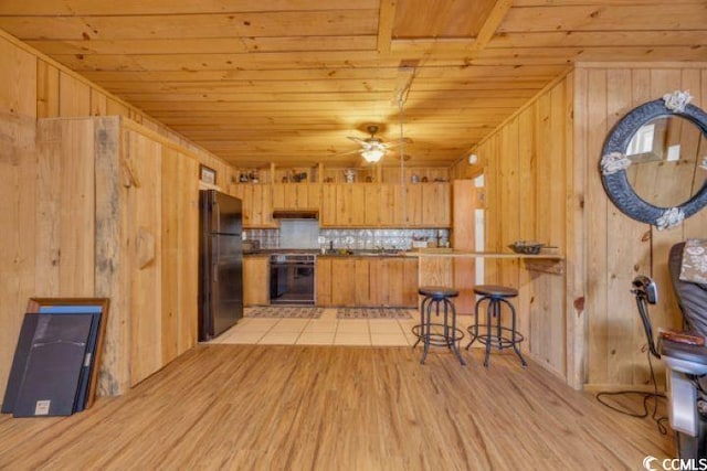 kitchen featuring kitchen peninsula, wooden ceiling, ceiling fan, and black appliances