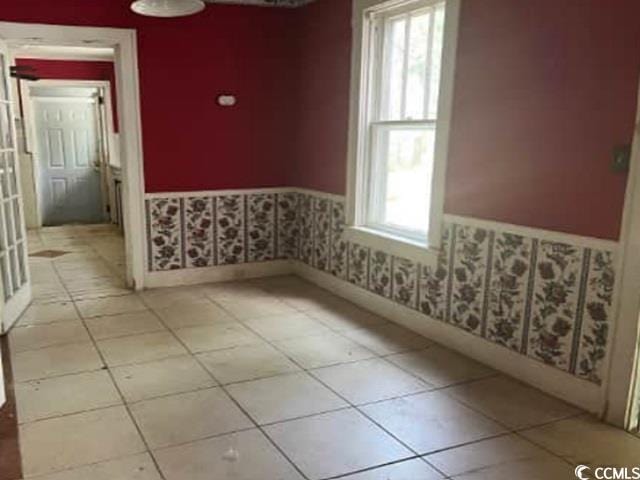 116 Singletary Ave, Lake City, SC 29560 - unfurnished room featuring a wainscoted wall, healthy amount of natural light, wallpapered walls, and tile patterned floors