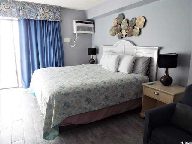 bedroom featuring hardwood / wood-style flooring and a wall unit AC