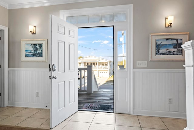 foyer entrance featuring crown molding and light tile patterned floors