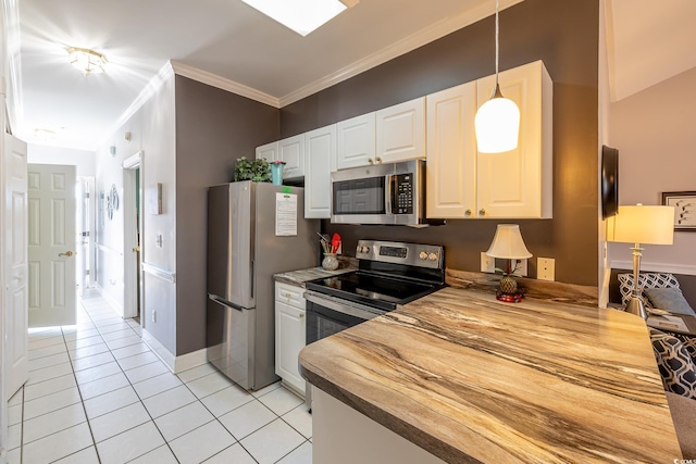 kitchen featuring light tile patterned floors, stainless steel appliances, white cabinets, decorative light fixtures, and crown molding