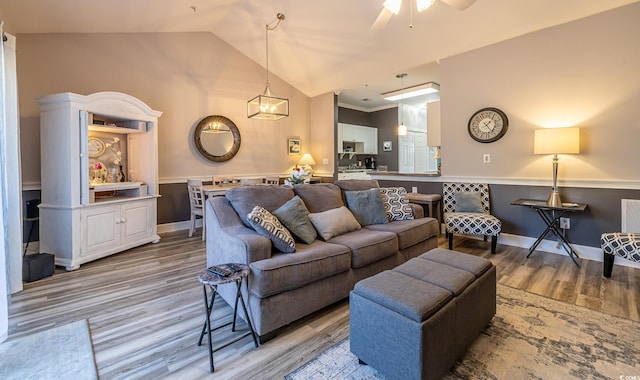 living area featuring light wood-type flooring, lofted ceiling, ceiling fan, and baseboards