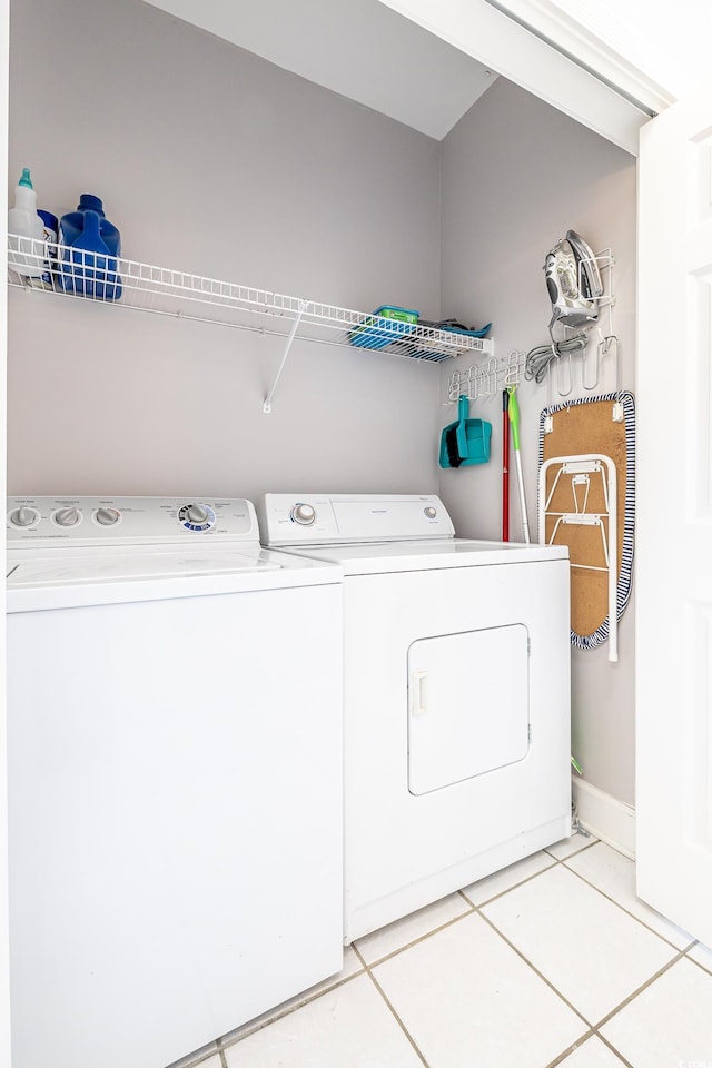 laundry room with washer and dryer, laundry area, baseboards, and light tile patterned floors