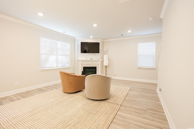 sitting room featuring crown molding, a wealth of natural light, and light wood-type flooring