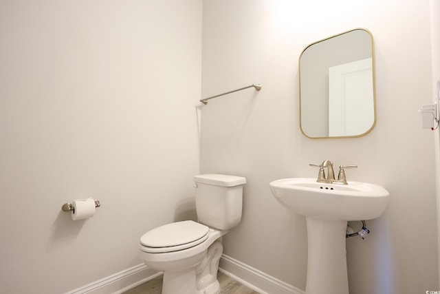 bathroom with sink, toilet, and hardwood / wood-style floors