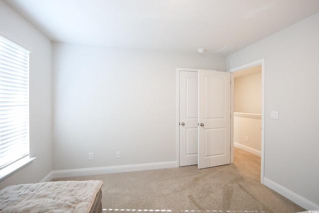 unfurnished bedroom with multiple windows and light carpet