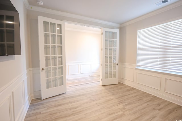 unfurnished room featuring crown molding, light hardwood / wood-style floors, and french doors