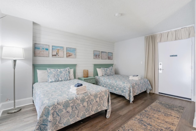 bedroom featuring a textured ceiling and dark hardwood / wood-style flooring