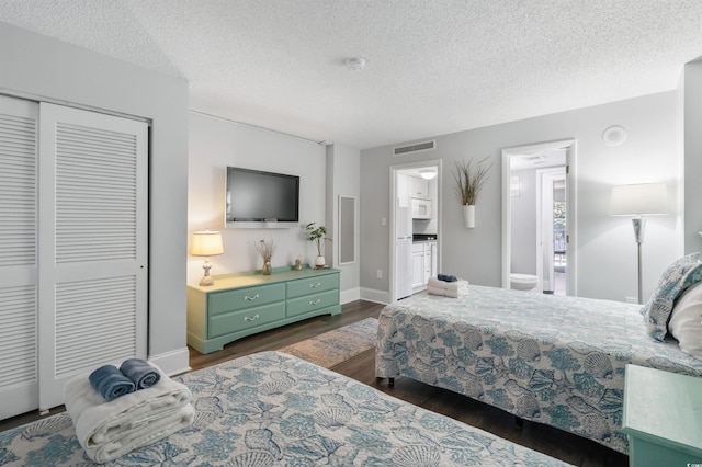 bedroom featuring dark hardwood / wood-style floors, a textured ceiling, and a closet