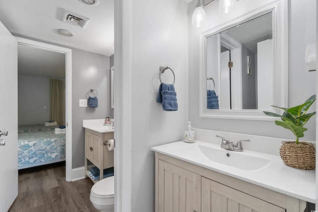 bathroom with vanity, hardwood / wood-style flooring, and toilet