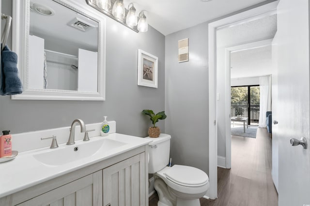 bathroom with vanity, hardwood / wood-style flooring, and toilet