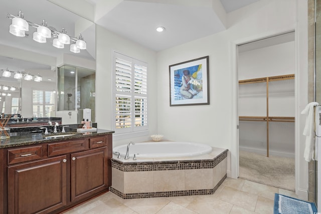 bathroom with tile patterned flooring, vanity, and shower with separate bathtub