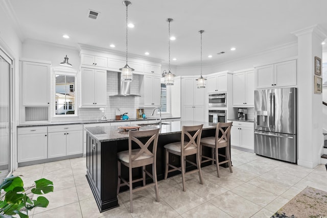 kitchen with white cabinets, a kitchen island with sink, wall chimney exhaust hood, and stainless steel appliances