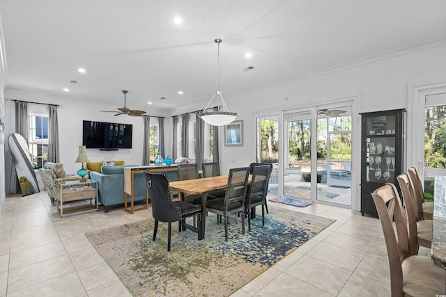 tiled dining area featuring ceiling fan and crown molding