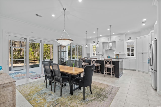 tiled dining room featuring crown molding