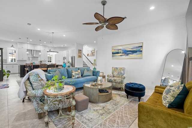 tiled living room with ceiling fan and crown molding