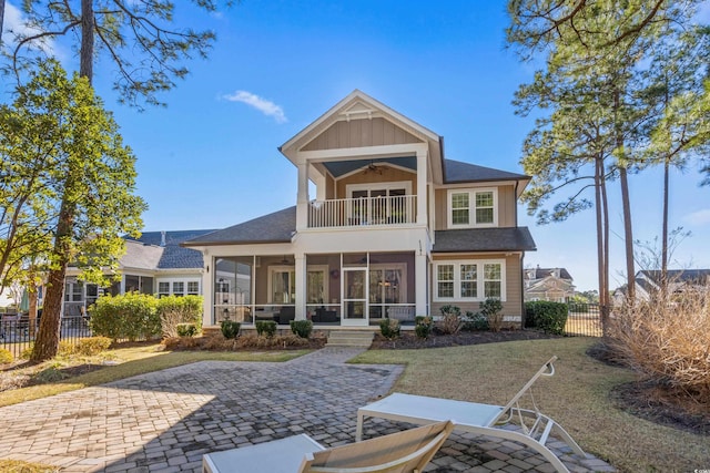 view of front of house featuring a patio, a balcony, ceiling fan, and a sunroom