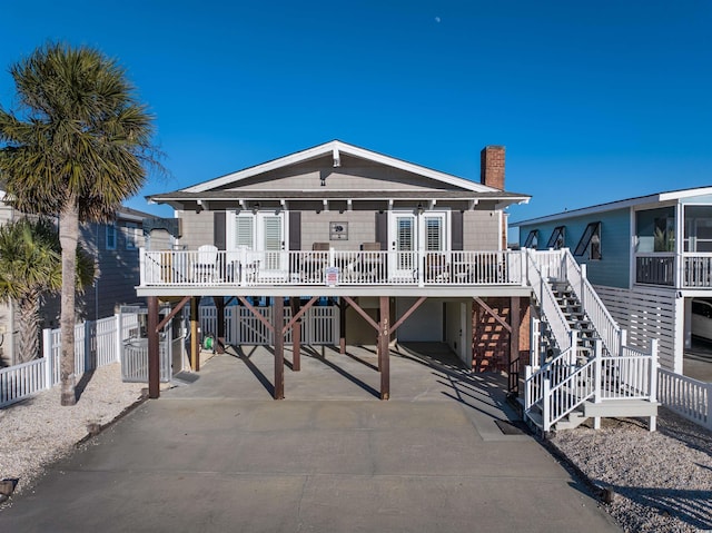 back of house with a carport and a porch