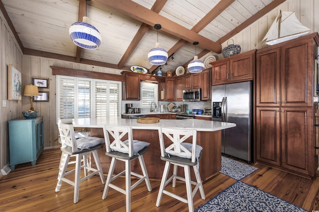 kitchen with a center island, stainless steel appliances, dark hardwood / wood-style flooring, lofted ceiling with beams, and decorative light fixtures