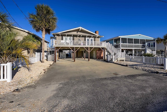 view of front of house with a sunroom, a porch, and a carport