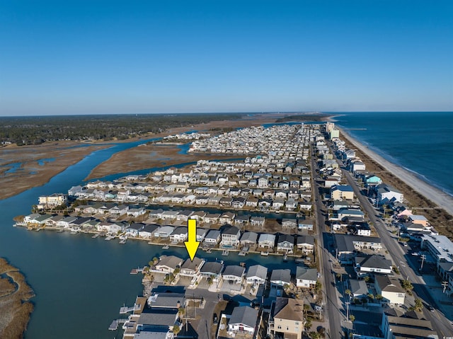 drone / aerial view featuring a water view and a beach view