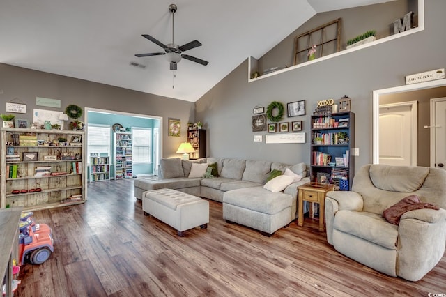 living room featuring hardwood / wood-style flooring, high vaulted ceiling, and ceiling fan