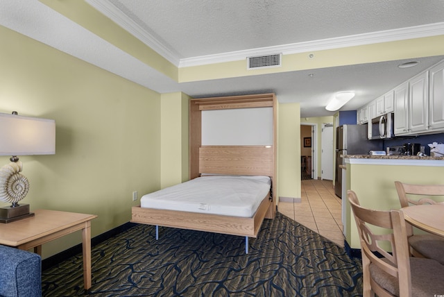 bedroom featuring light tile patterned floors, a textured ceiling, and ornamental molding