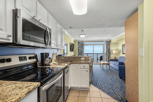 kitchen featuring stainless steel appliances, white cabinetry, and stone countertops