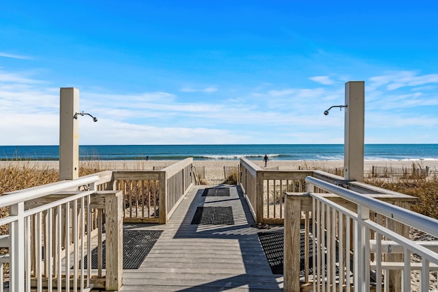 view of home's community featuring a water view and a beach view