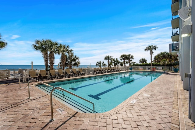 view of pool with a water view and a patio area