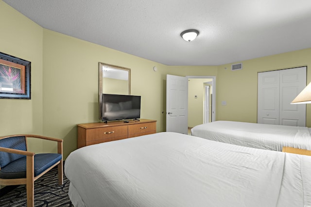 bedroom with a textured ceiling and a closet