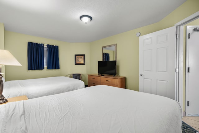 bedroom with tile patterned floors and a textured ceiling