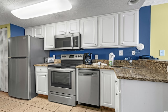 kitchen featuring sink, white cabinetry, stainless steel appliances, and light tile patterned floors