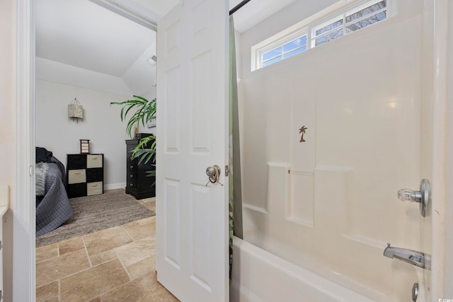 bathroom featuring bathtub / shower combination and vaulted ceiling