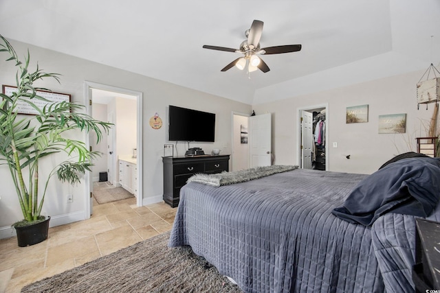 bedroom featuring ensuite bathroom, ceiling fan, a spacious closet, a tray ceiling, and a closet