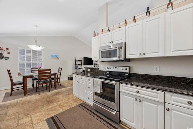 kitchen with white cabinets, vaulted ceiling, dark stone countertops, decorative light fixtures, and stainless steel appliances