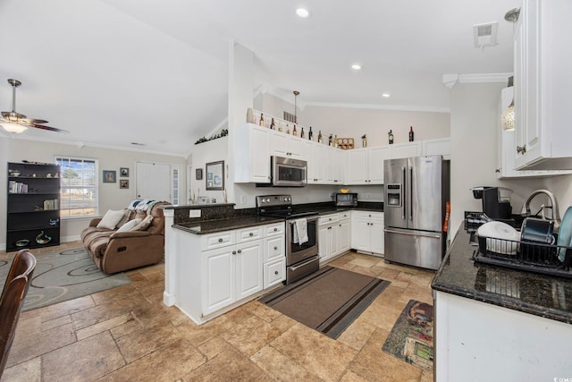 kitchen with lofted ceiling, crown molding, ceiling fan, white cabinetry, and stainless steel appliances