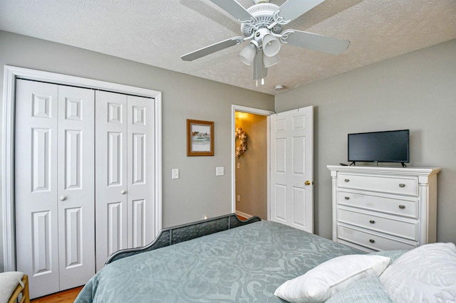 bedroom with a textured ceiling, ceiling fan, and a closet