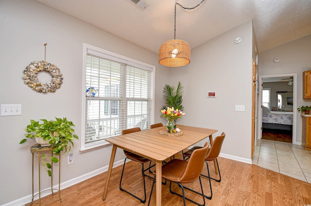 dining space featuring lofted ceiling and light hardwood / wood-style flooring