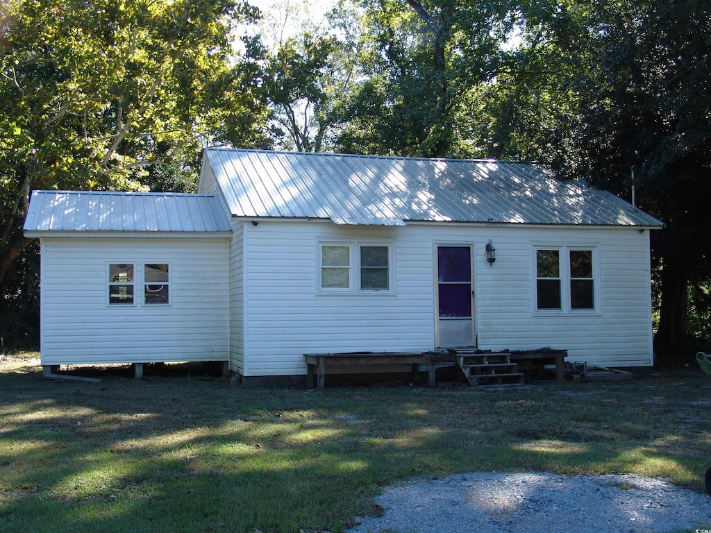 back of property featuring a yard