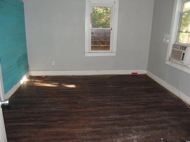 empty room featuring cooling unit and dark wood-type flooring